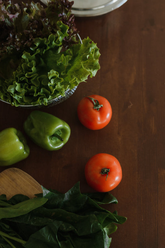 Home grown tomatoes and salad greens being prepared for a meal in the kitchen.